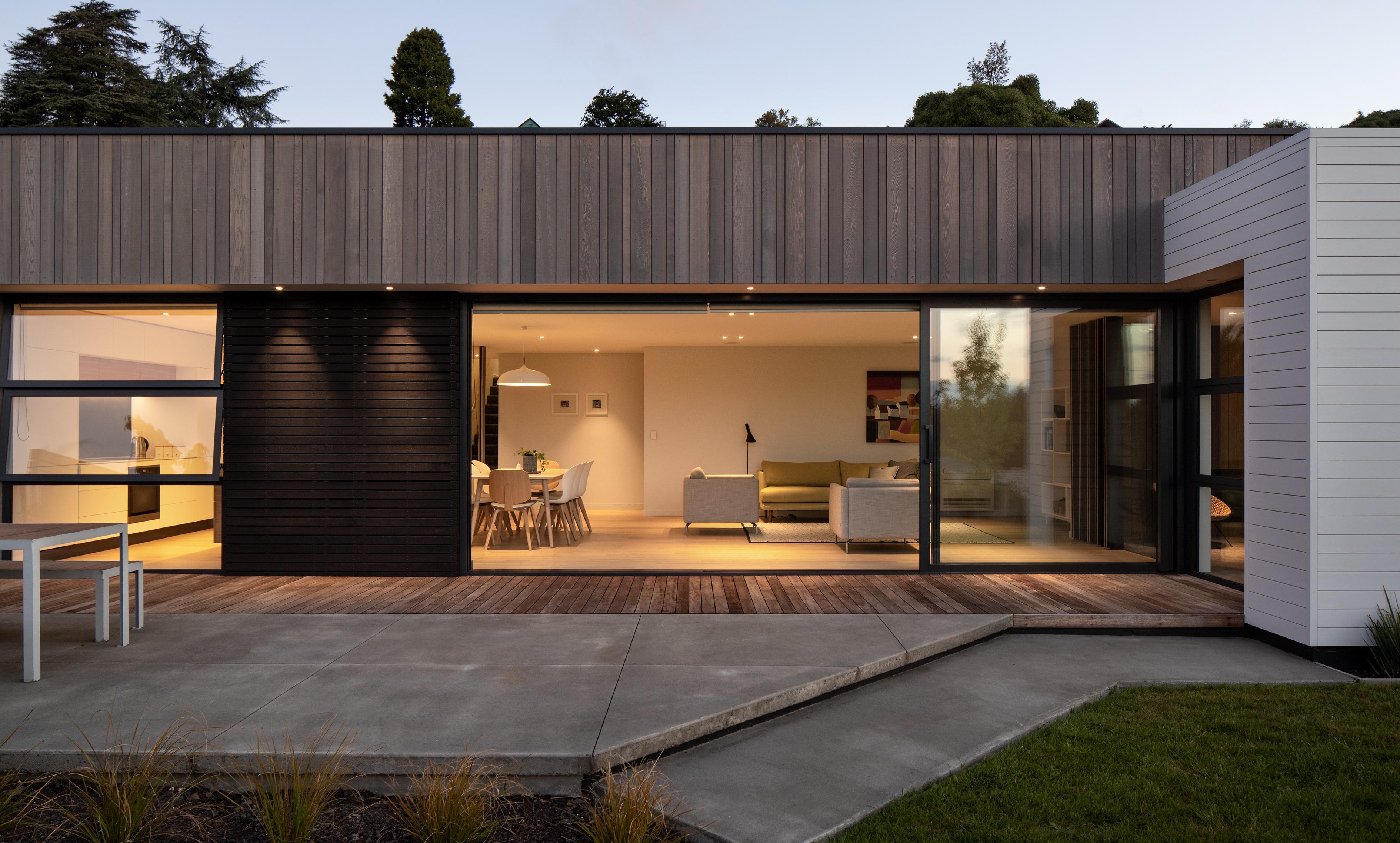 View from outside looking back into the Broad Oaks living area, illuminated at dusk