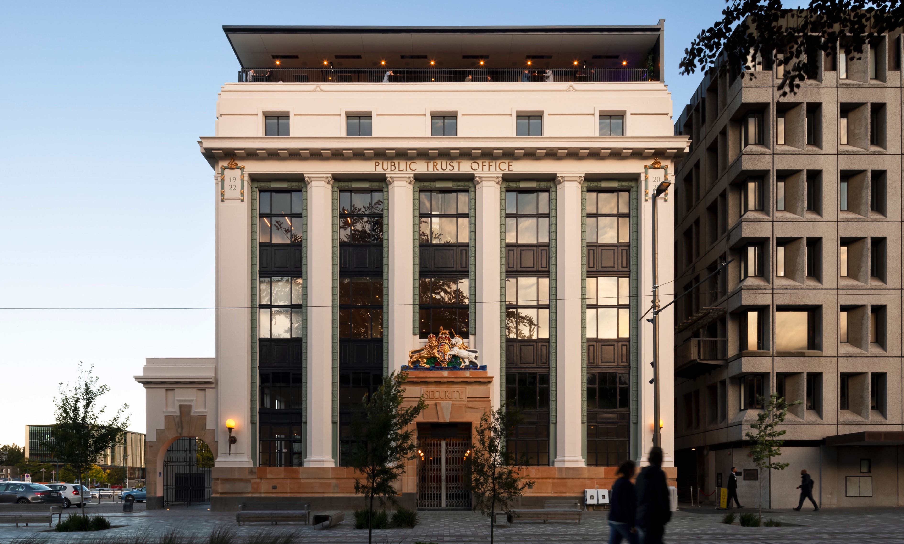 Exterior of Public Trust facade. People walking in foreground.