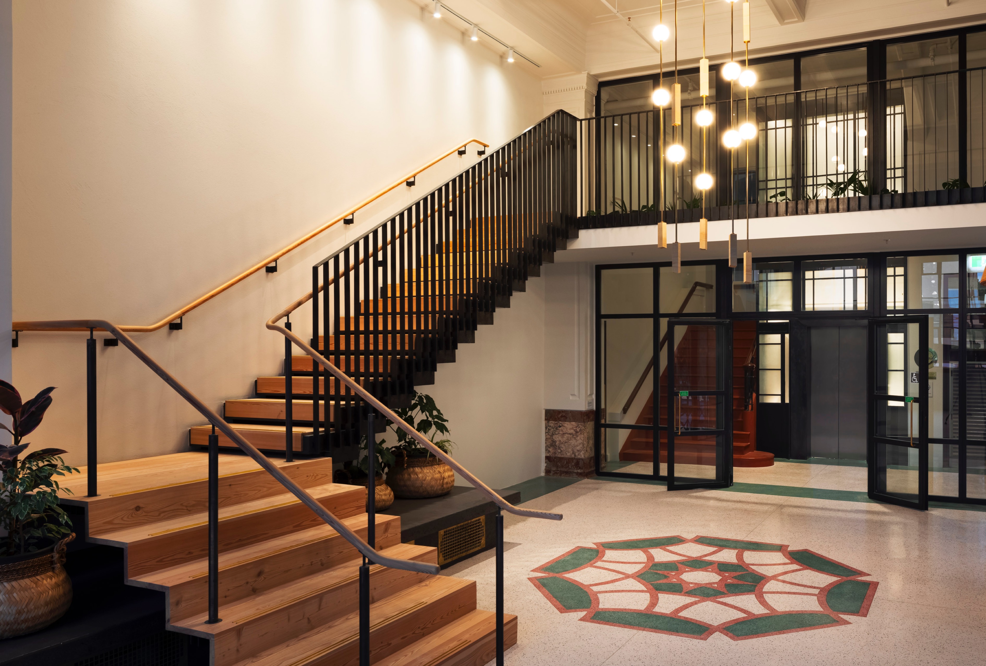 Foyer with staircase, art deco lighting, and tilework