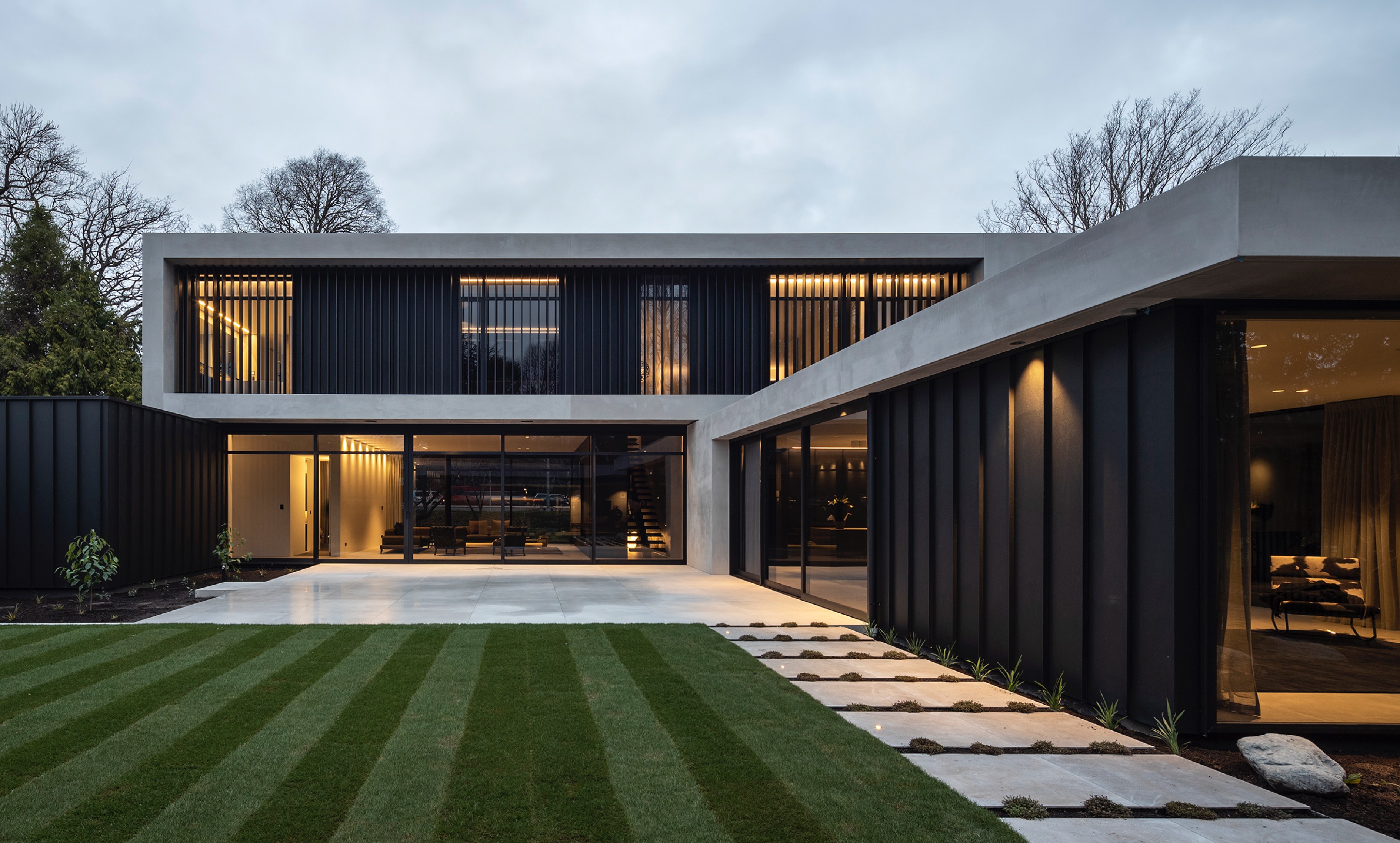 Exterior of Riverside House patio area with green lawn and light filtering through louvres